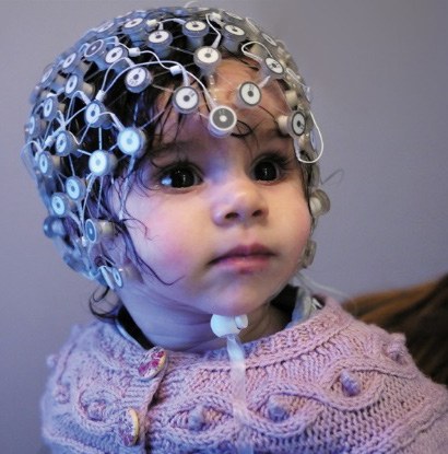 Young child wearing a high-density EEG net